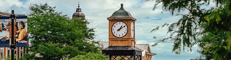 Official Plan review A clock tower with a cupola in the background and lots of trees