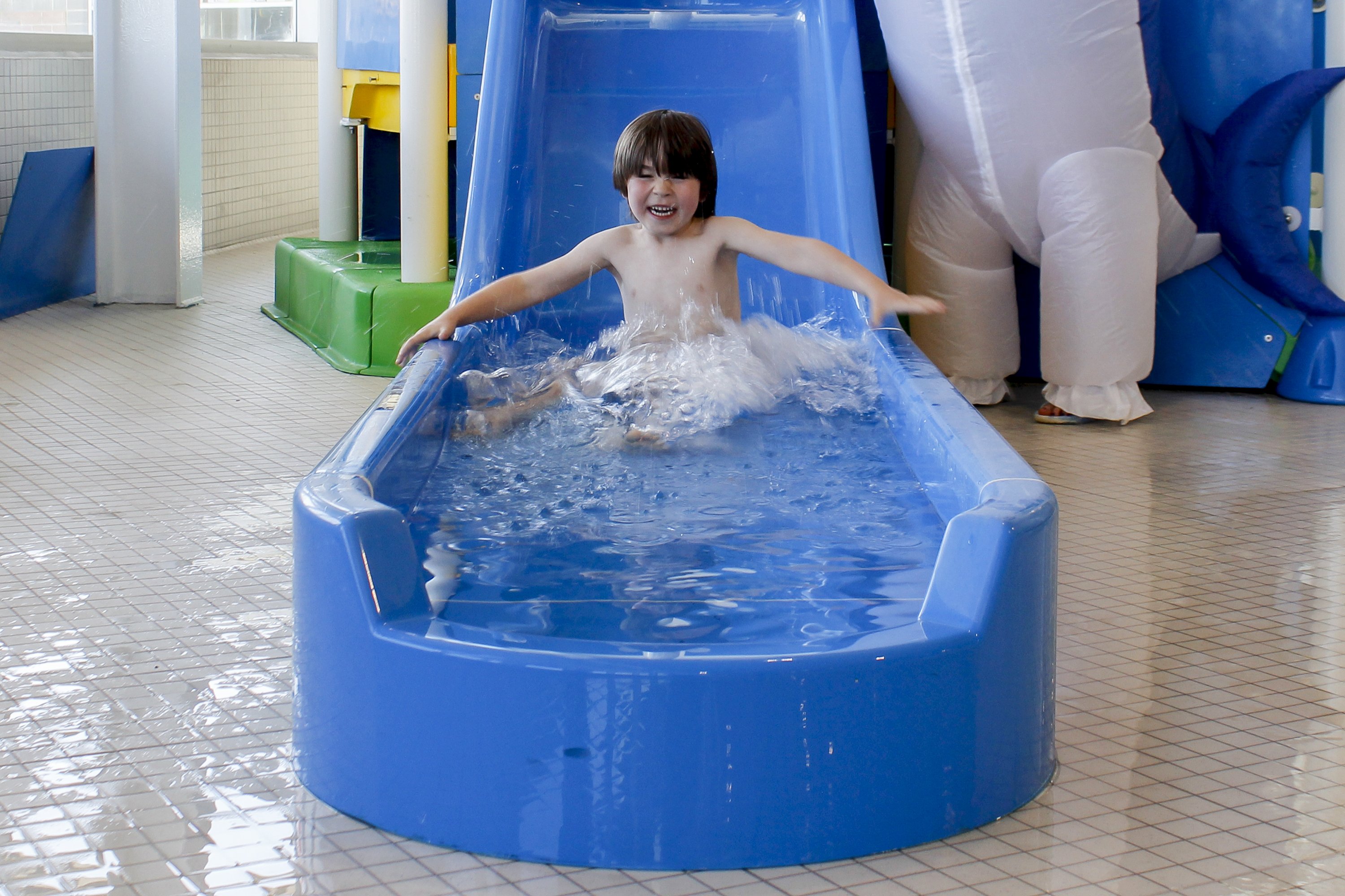 A child splashes down a water slide