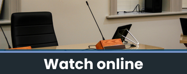 A picture of a council chamber with the words 'watch online'