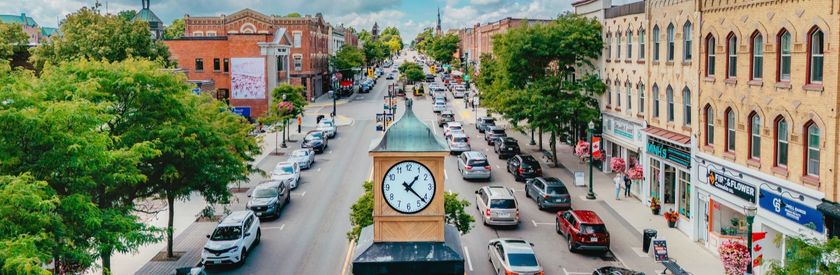 Budget and Finances A web banner with the words Budget and Finances. The background of the banner is a very dark blue. In a semi-circle on the left of the banner is an image with a statue in the middle of stone walls, with plants on either side, and a historic building, known as Orangeville's Town Hall and historic theatre.