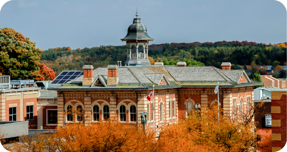 A photo of a historical building, with the bottom half blocked by trees in the fall.