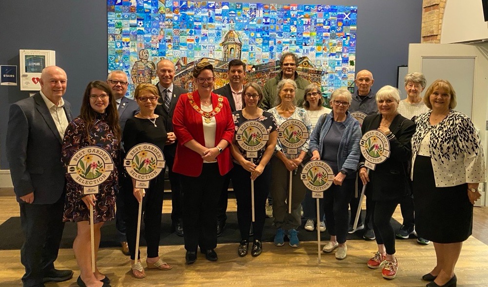 Individuals and Council members holding garden signs 