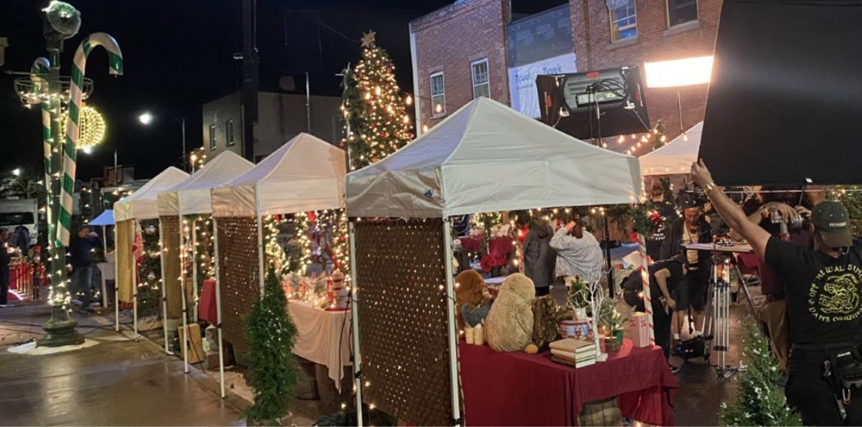 A film crew filming a holiday market on a historic street